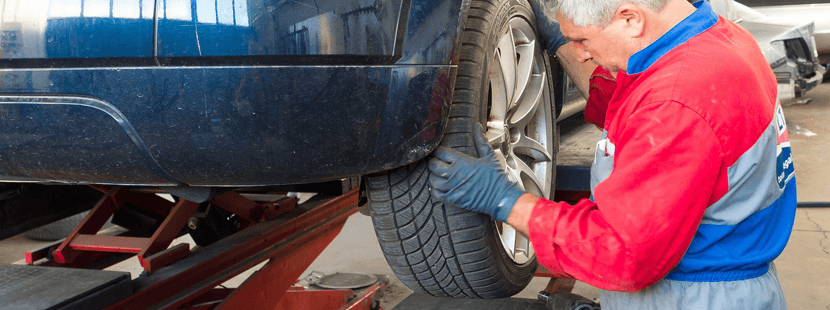 Automechaniker in Uniform bei der Arbeit am Auto